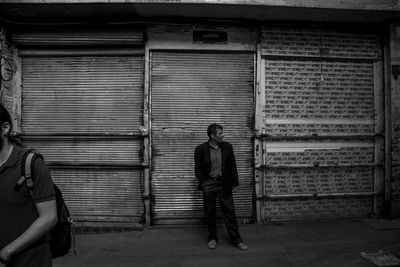 Full length rear view of man walking against building