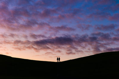 Silhouette man standing against sky during sunset