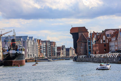 Buildings by sea against sky in city