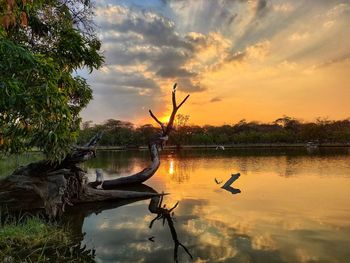 Scenic view of lake against sky at sunset