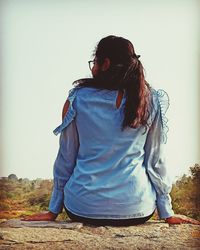 Rear view of woman standing against sky