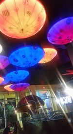 Low angle view of illuminated lanterns hanging at night