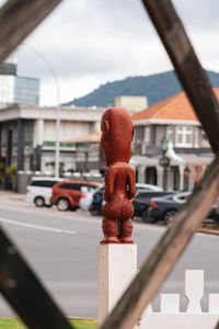 Close-up of red car against building in city