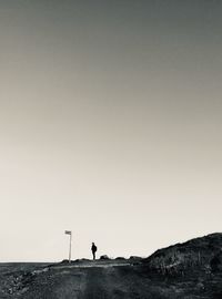 Silhouette man standing on land against clear sky