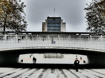 Full length of woman walking in city against sky