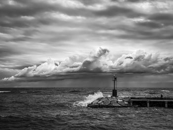 Lighthouse by sea against sky