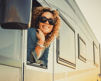 Portrait of young woman wearing sunglasses while standing in bathroom