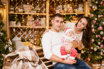 Winter holidays and people concept - happy young family dad mom and little son