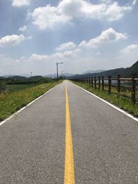 Empty road against cloudy sky