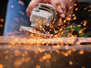 Cropped hands cutting metal in workshop