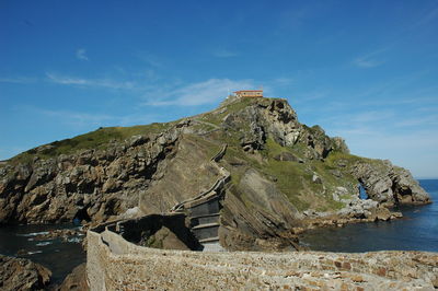 Scenic view of sea and mountains against blue sky