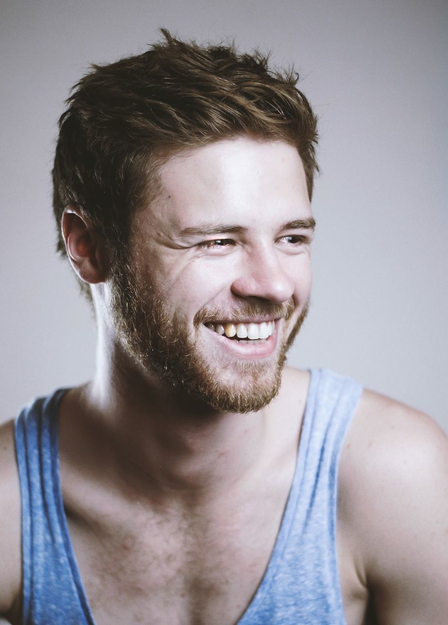 young adult, portrait, looking at camera, person, front view, headshot, lifestyles, young men, indoors, casual clothing, studio shot, confidence, leisure activity, close-up, smiling, serious, beard