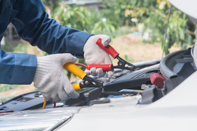 Midsection of man working in car