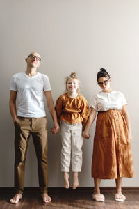 Portrait of family standing by wall