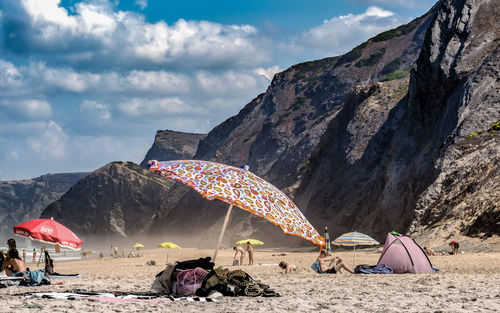 People on beach against mountain