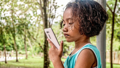 Side view of girl using mobile phone