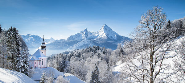 Maria gern church on snowcapped mountains against blue sky