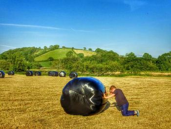 Scenic view of grassy field against blue sky