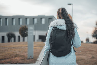 Rear view of woman standing against building