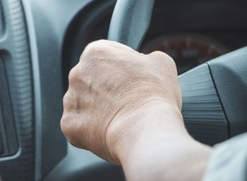 Close-up of man hand in car