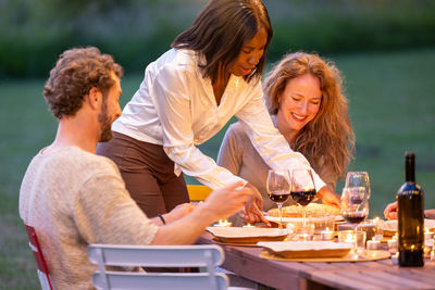 Side view of friends sitting on table