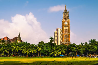 Panoramic view of buildings and trees against sky in city