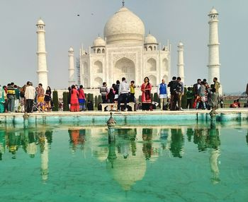 People in front of historical building against clear sky