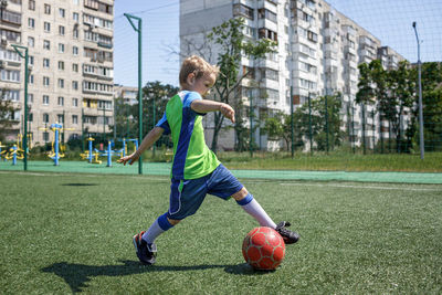 Full length of boy playing with ball