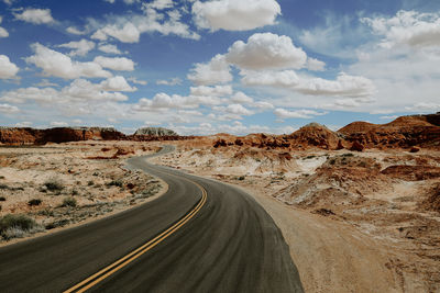 Road passing through desert against sky