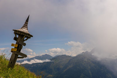 Cross on mountain against sky