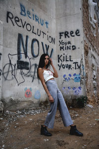 Full length of woman standing against building in city