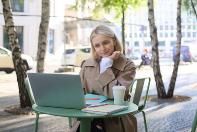 Young woman using laptop at cafe