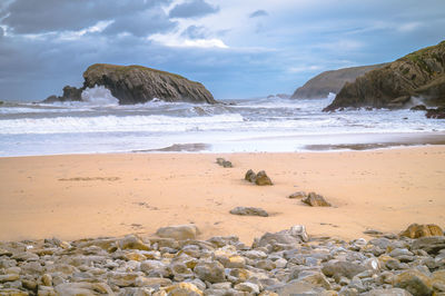 Rocks on beach against sky