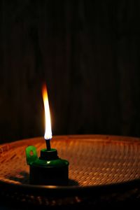 Close-up of lit candle in the dark