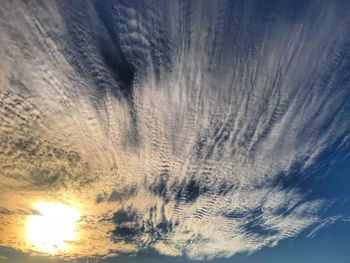 Low angle view of snow against sky during sunset