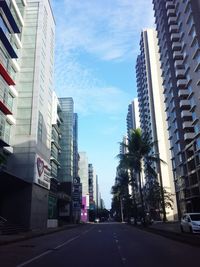 Road amidst buildings in city against sky