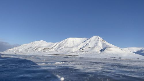 Scenic view of snowcapped mountains against clear blue sky -svalbard 