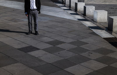 Portrait of adult man in suit standing on public business area