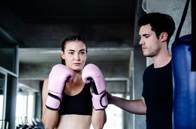 Man looking at woman while preparing for boxing in rink