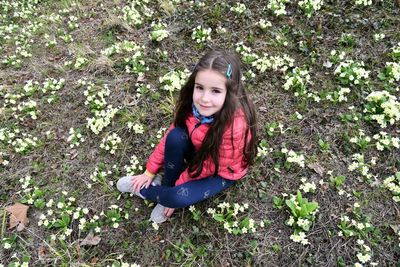 High angle portrait of smiling girl sitting on field