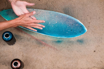 Close-up of hand on wet sand