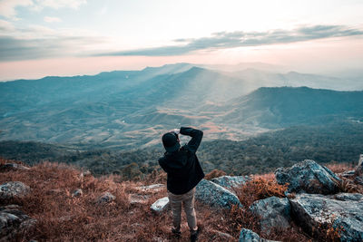 Rear view of man on mountain against sky