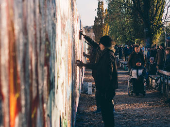Rear view of people on sidewalk in city