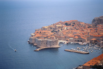 Aerial view of cityscape by sea against sky