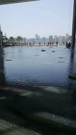 Boats in river with city in background