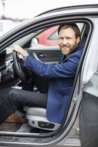 Side view portrait of mid adult businessman sitting in car