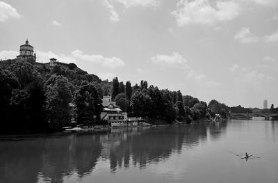 Scenic view of lake and buildings against sky