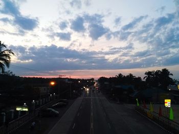 View of city street against sky at sunset