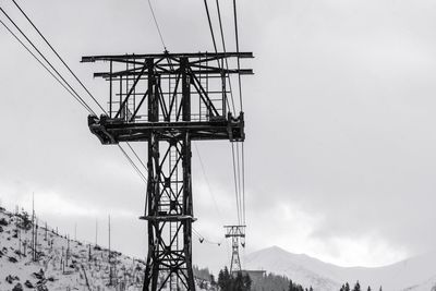 Low angle view of electricity pylon against sky