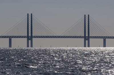 Bridge over sea against clear sky